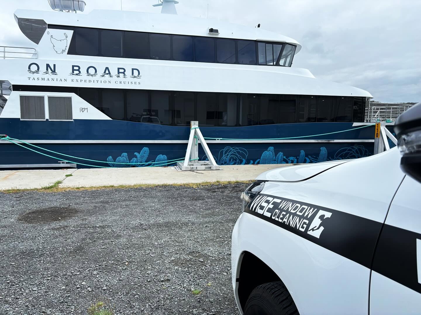 Branded Wise Window Cleaning vehicle alongside an expedition vessel